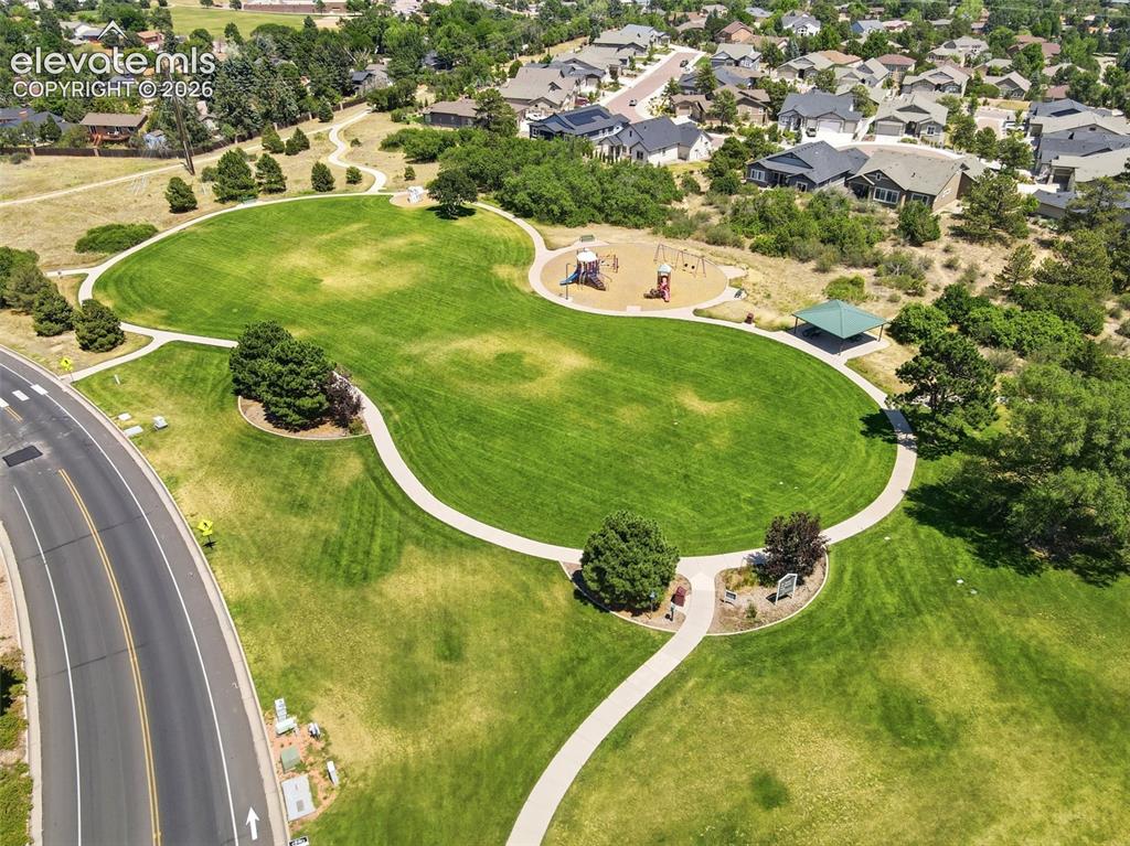 Image 45 of 50: Expansive community park featuring manicured lawns, a winding pedestrian pa