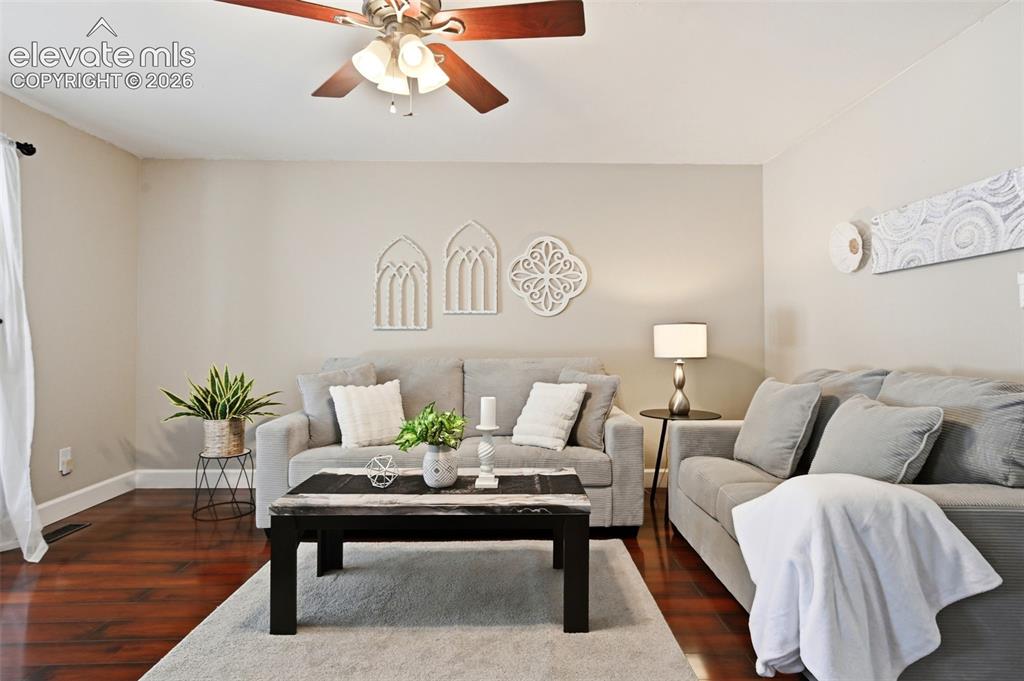 Image 5 of 50: Living area featuring wood-finish flooring, a ceiling fan with integrated l