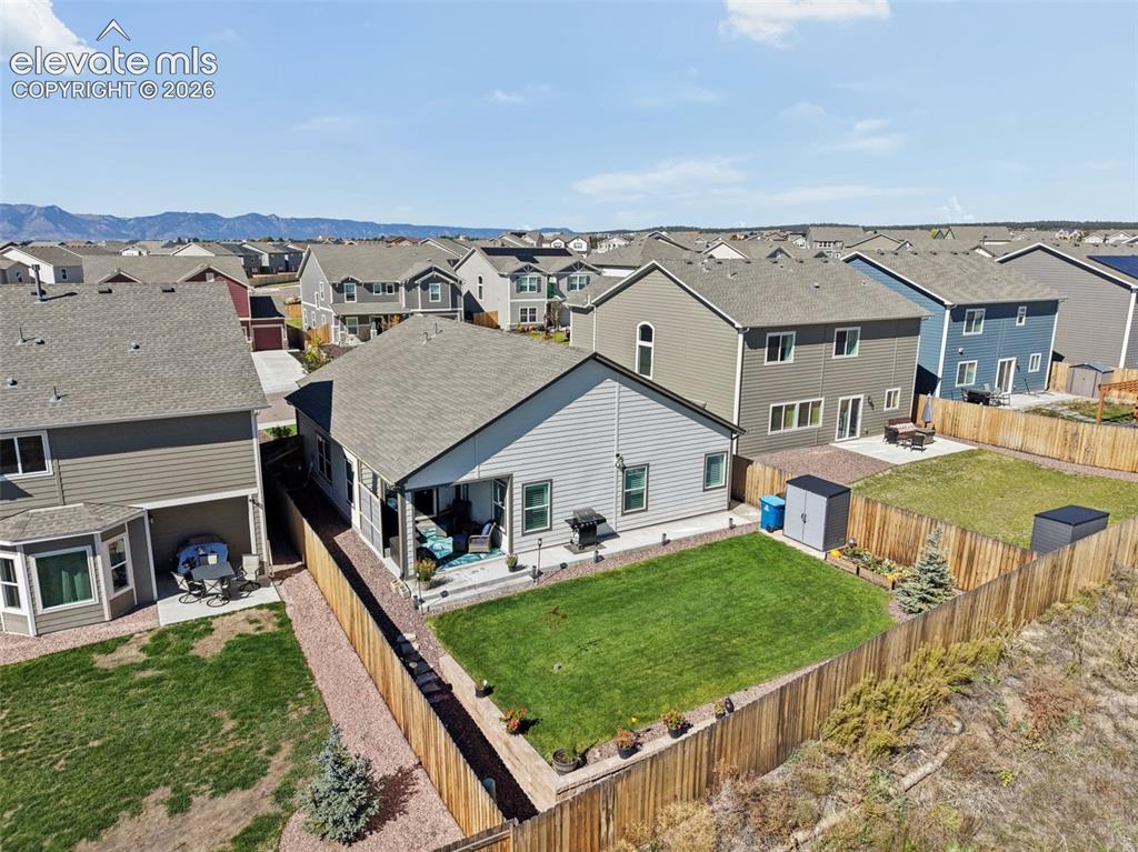 Image 8 of 35: Landscaped back yard with extended patio and sidewalk, raised garden bed an
