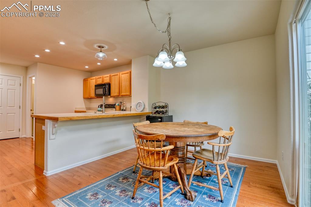 Image 15 of 43: Dining space featuring light wood-style flooring, a chandelier, and recesse