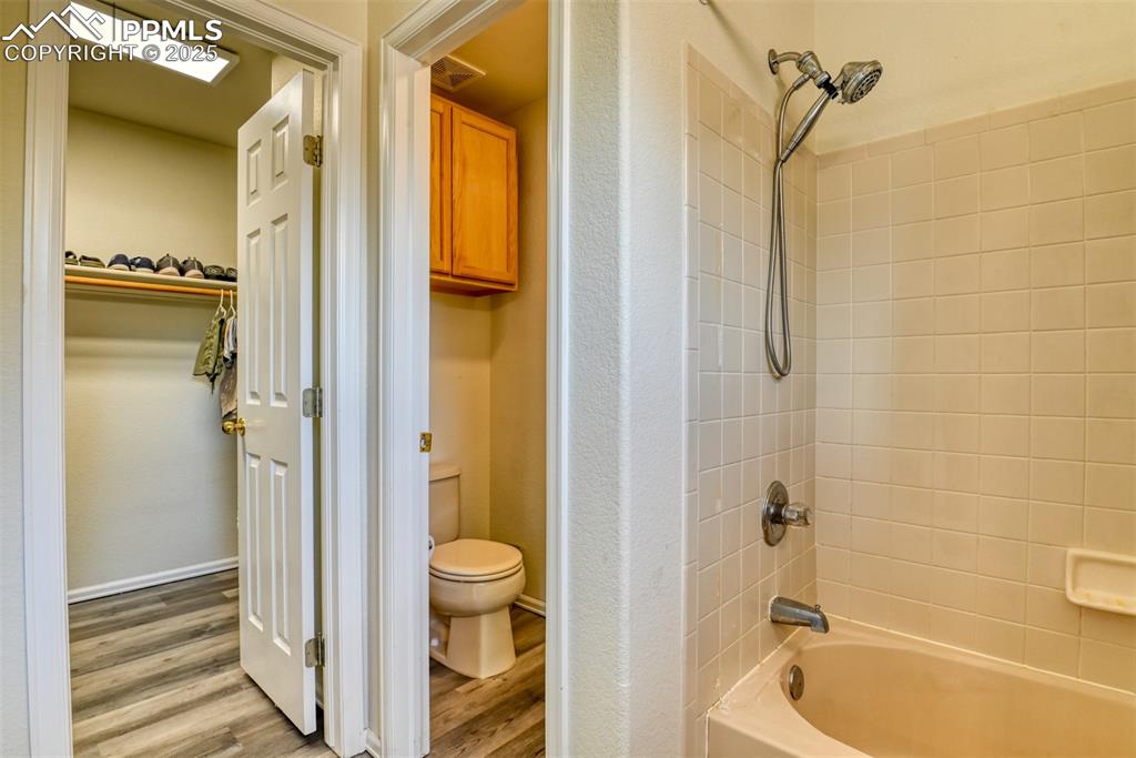 Image 24 of 43: Bathroom featuring brand new flooring, shower combination, and a spacious