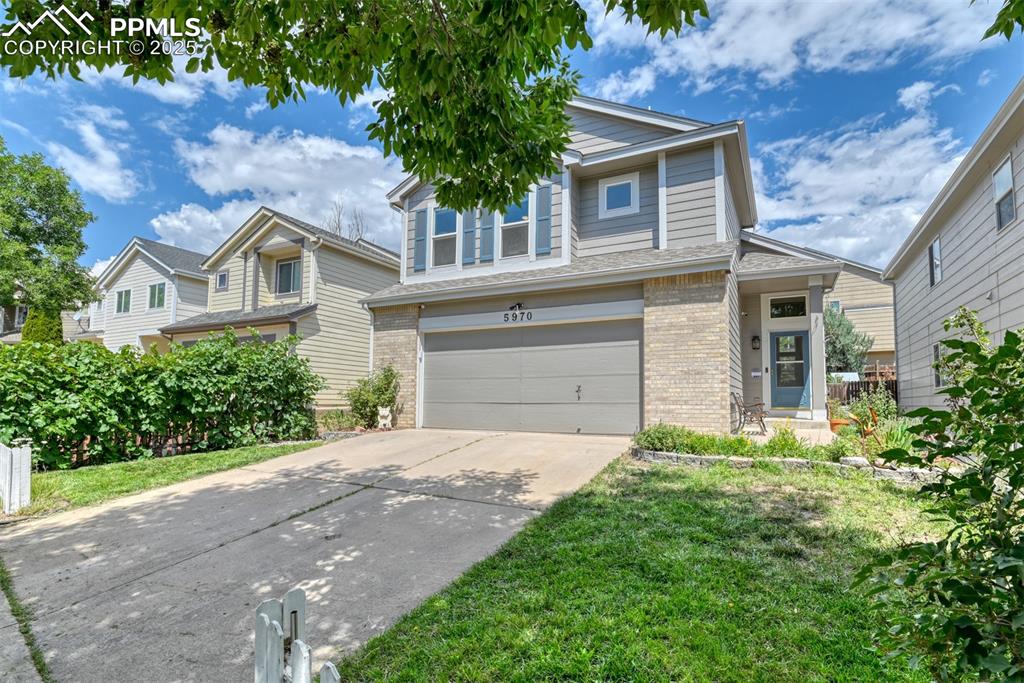Image 3 of 43: View of front facade featuring a garage, brick siding, driveway, and a fron
