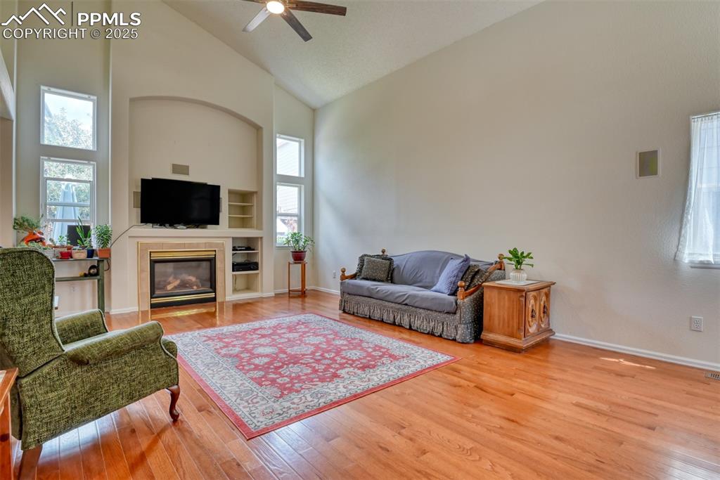 Image 5 of 43: Living area with light wood finished floors, high vaulted ceiling, plenty o