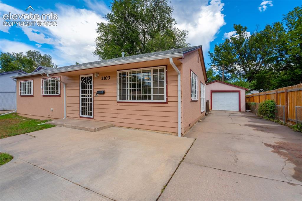 Caption: Single-story exterior with horizontal siding and a detached garage