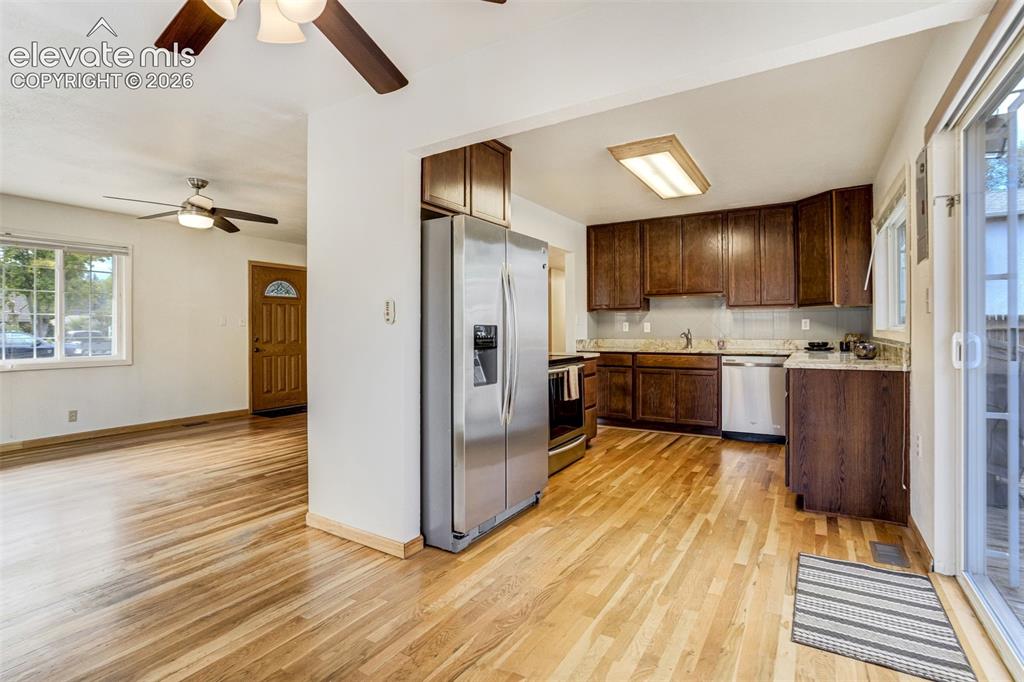 Image 10 of 31: Wood-finish flooring throughout, kitchen with wood cabinetry, stainless ste