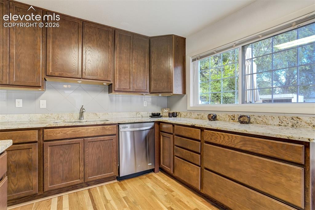 Image 12 of 31: Wood-finish cabinetry paired with light-toned countertops, a stainless stee
