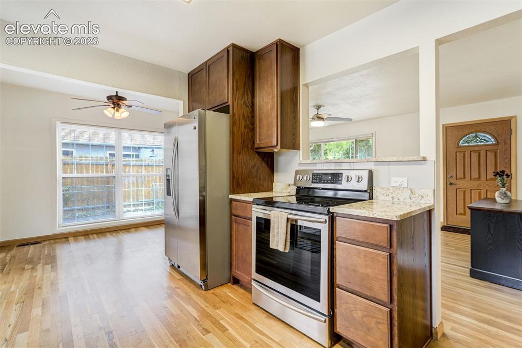 Image 13 of 31: Kitchen featuring stainless steel appliances, wood-finish flooring, granite