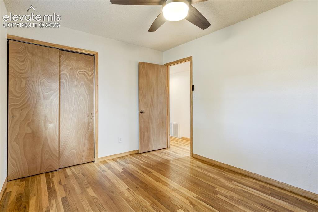 Image 16 of 31: Wood-finish flooring throughout, featuring a ceiling fan with integrated li