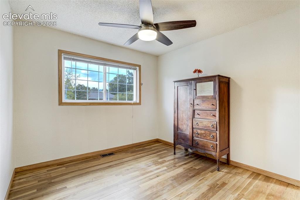 Image 17 of 31: Wood-finish flooring, light-toned walls, and a multi-pane window with wood