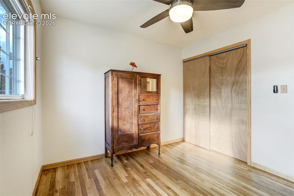 Image 18 of 31: Hardwood flooring, natural light through a window, built-in ceiling fan, an
