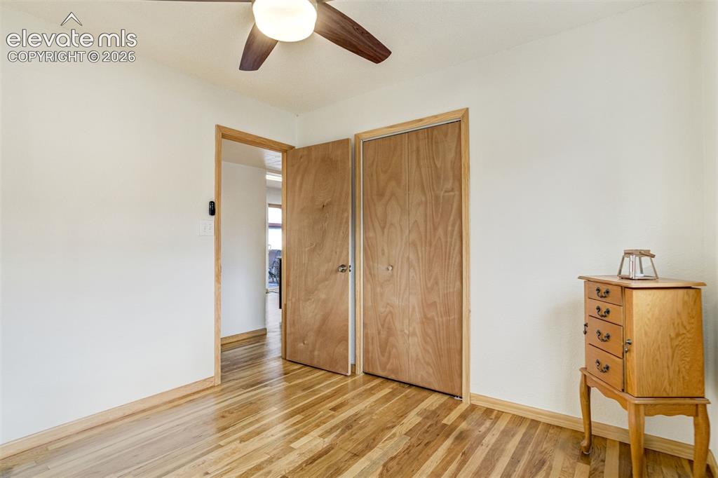 Image 22 of 31: Wood-finish flooring, light wood-tone doors, and a ceiling fan with integra