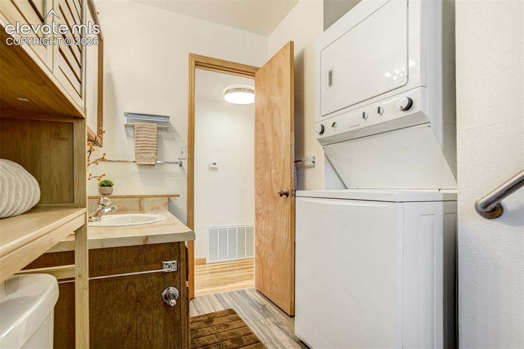 Image 24 of 31: Integrated laundry appliances, single vanity with light-toned countertop, w