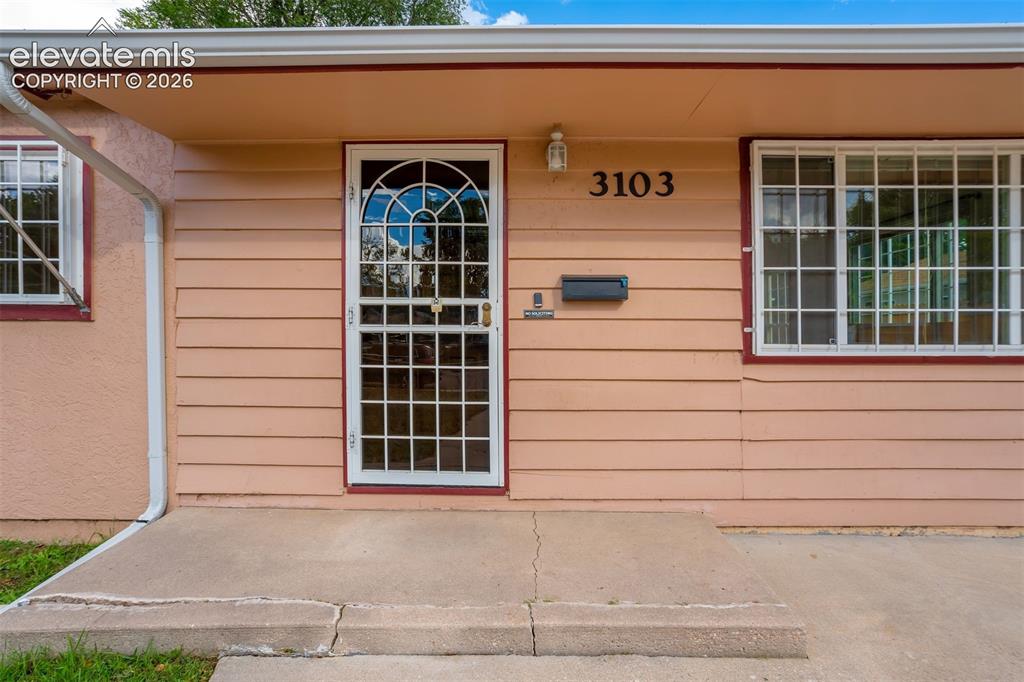 Image 4 of 31: Front facade featuring horizontal siding, a stucco section, a security scre