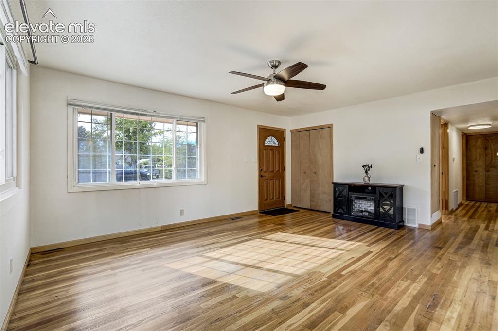 Image 5 of 31: Wood-finish flooring throughout, multi-pane window, ceiling fan with integr