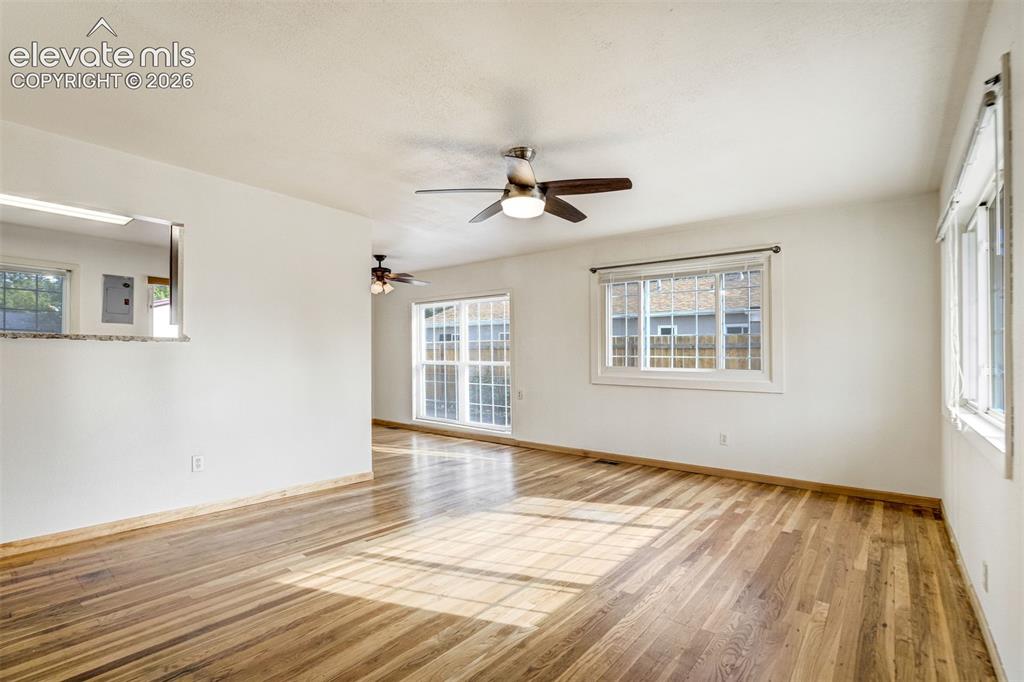 Image 7 of 31: Hardwood flooring throughout, multiple windows, ceiling fans, pass-through 