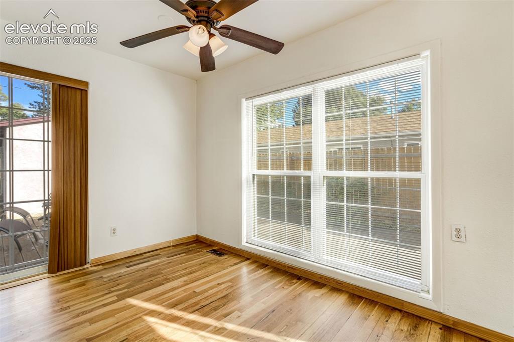 Image 9 of 31: Hardwood flooring, white walls, and a ceiling fan with integrated lighting