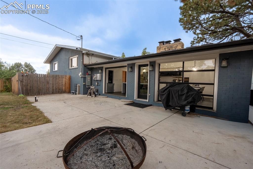 Image 12 of 49: Walk out patio off kitchen with roll up doors - main floor