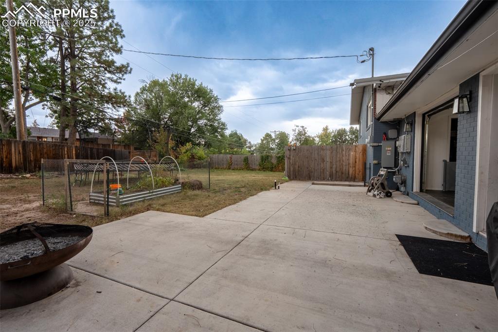 Image 13 of 49: Walk out patio off kitchen with roll up doors - main floor