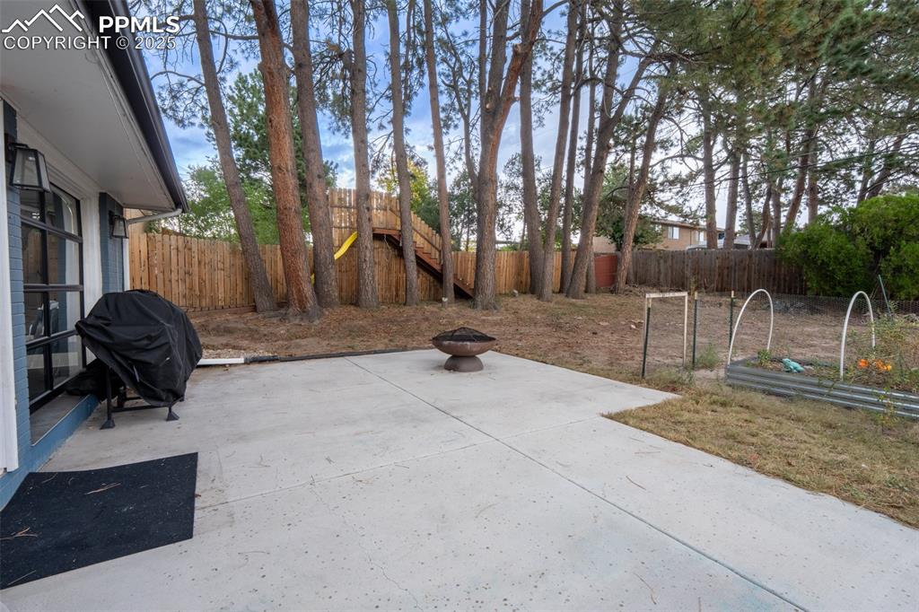 Image 14 of 49: Walk out patio off kitchen with roll up doors - main floor
