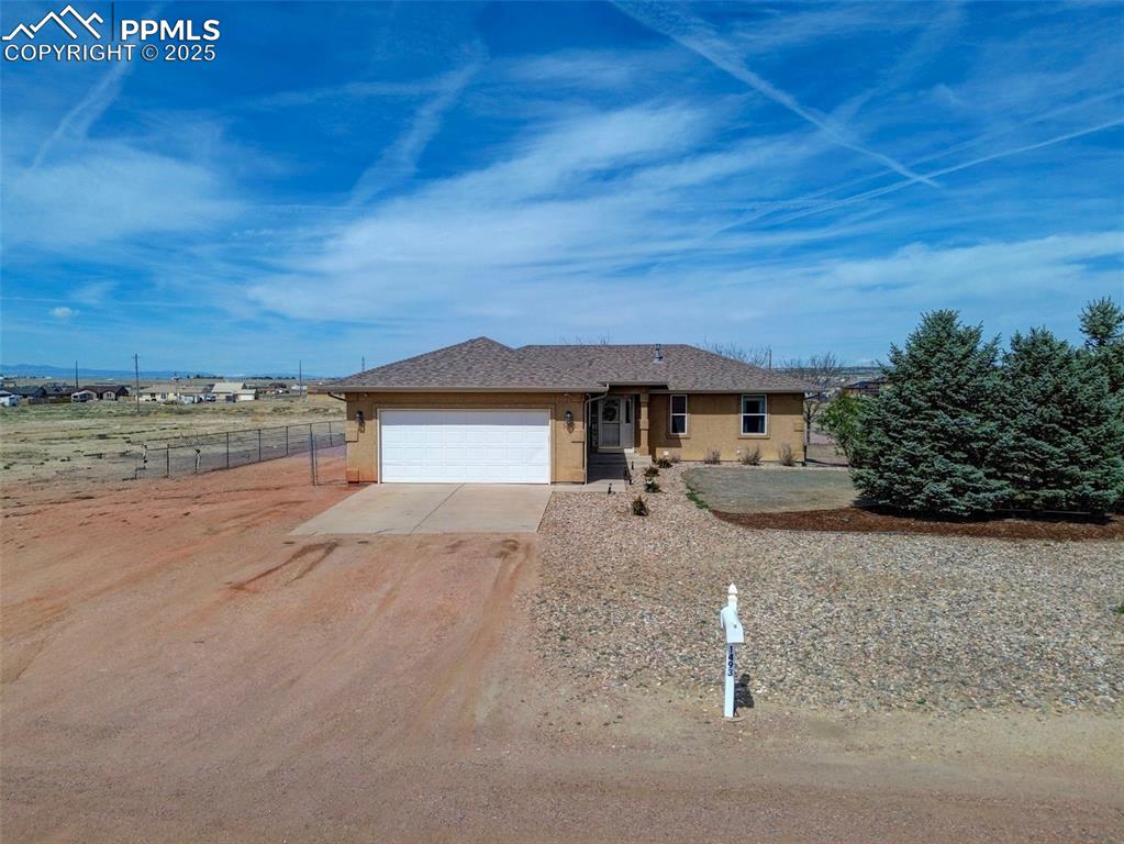 Caption: Single story home with a garage, driveway, and stucco siding