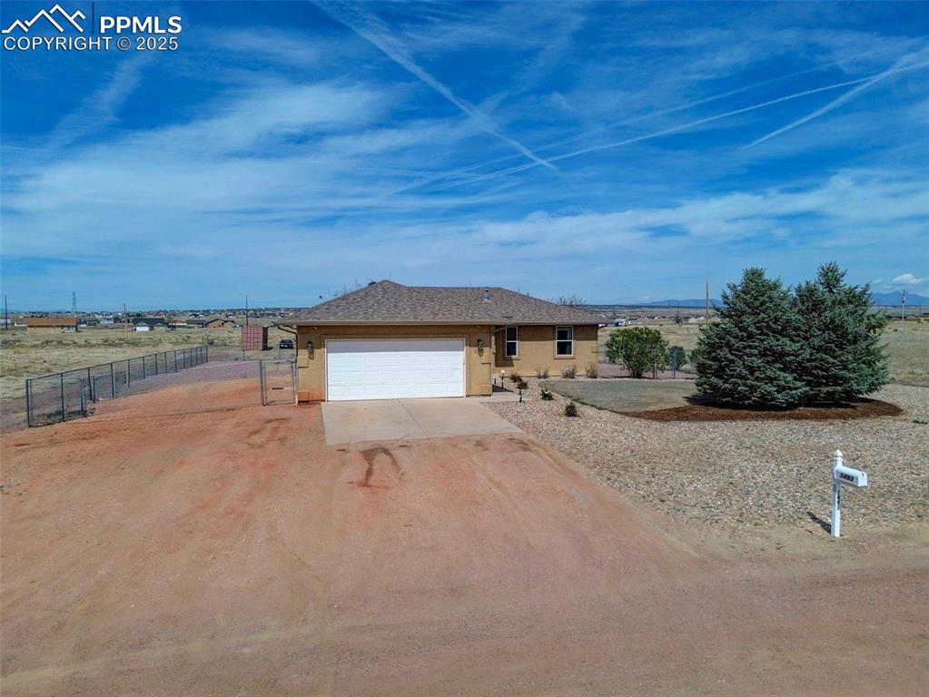 Image 2 of 34: Single story home with a garage, stucco siding, driveway, and a gate