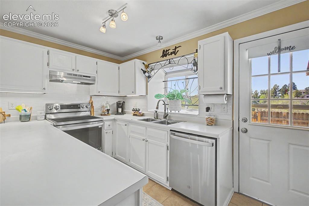 Image 12 of 31: Kitchen featuring light cabinets and counters and stainless steel appliance