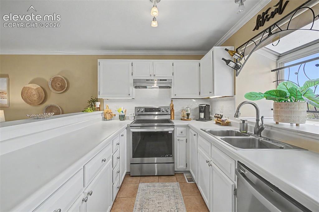 Image 13 of 31: Kitchen featuring light cabinets and counters and stainless steel appliance