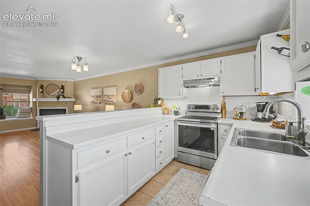 Image 14 of 31: Kitchen featuring light cabinets and counters and stainless steel appliance