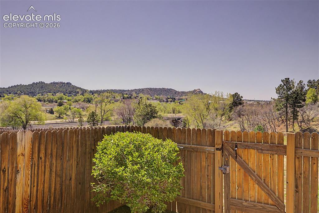 Image 26 of 31: Back of property, fenced with mountain views