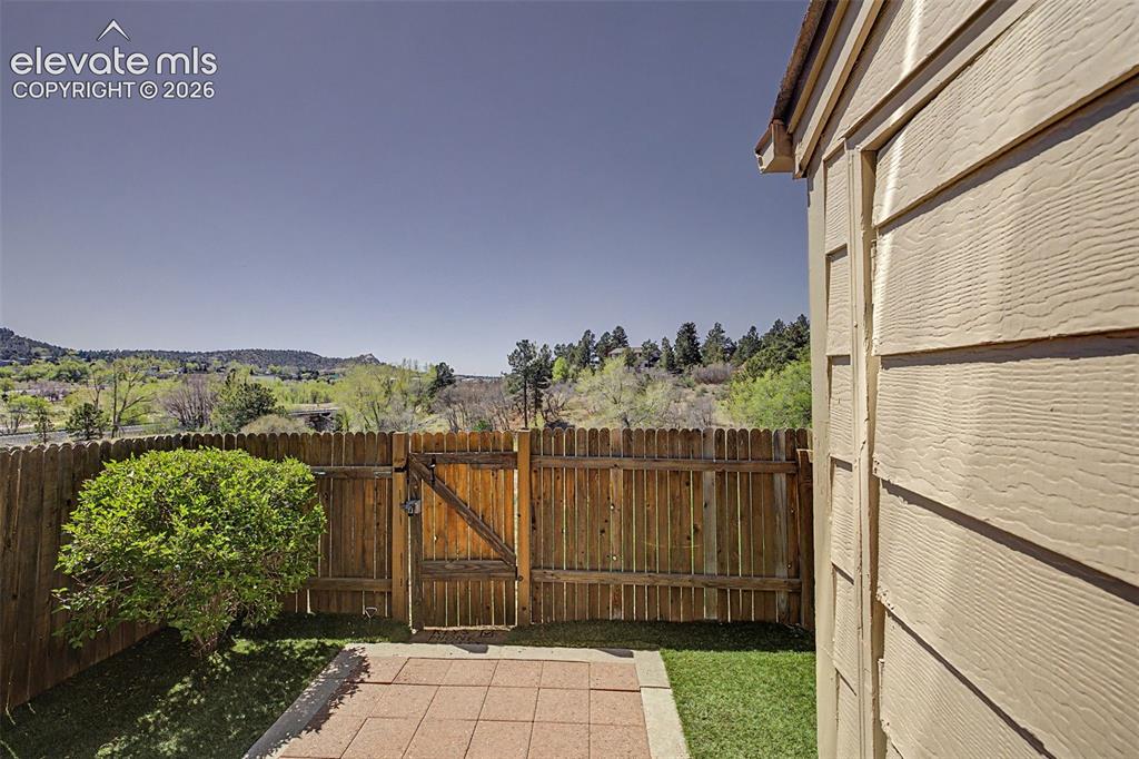 Image 27 of 31: Back of property, fenced, with concrete patio and turf