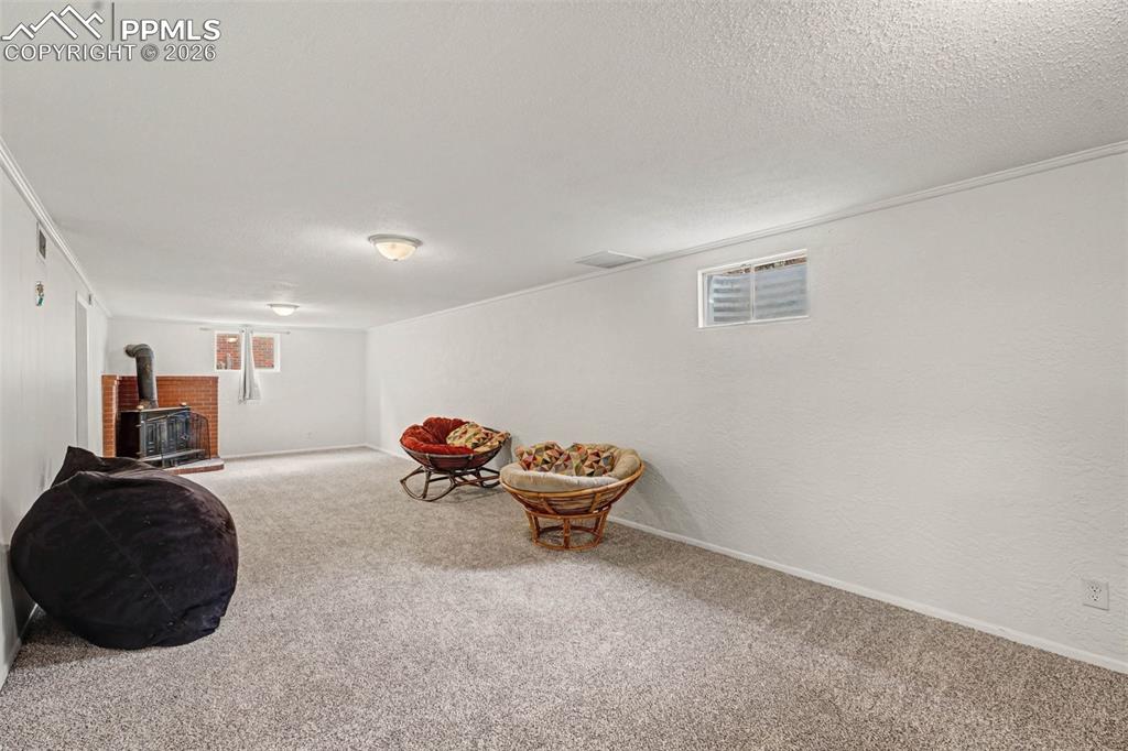 Image 10 of 23: Rec/living room with a wood stove, and new carpet