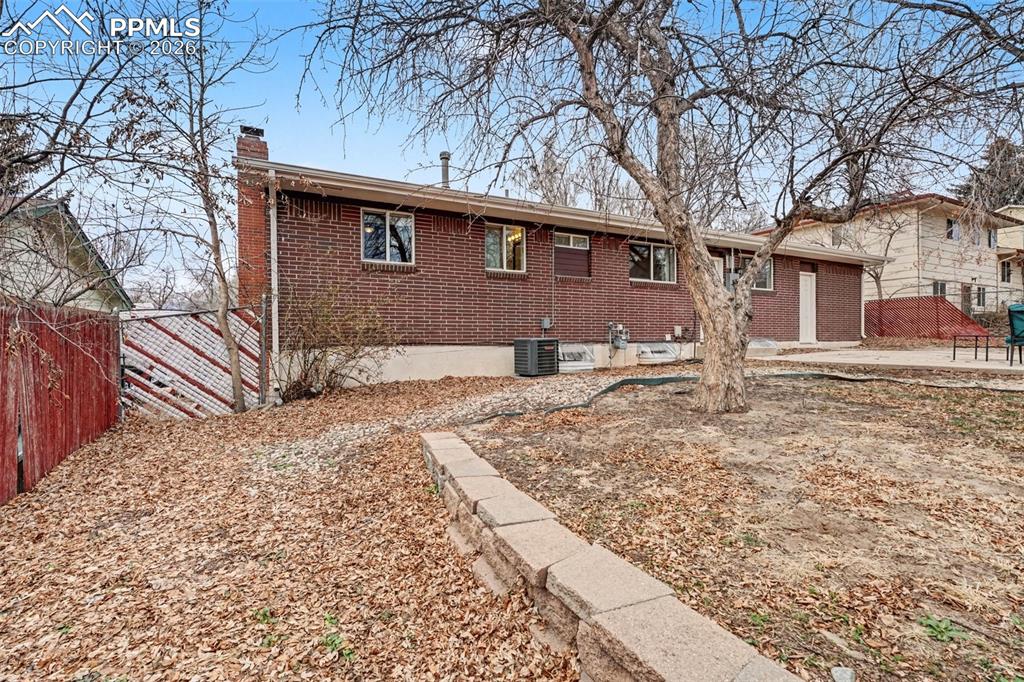 Image 18 of 23: View of front of house with a chimney and brick siding