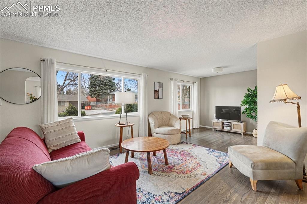 Image 2 of 23: Living room featuring wood finished floors, abundant natural light, and a t