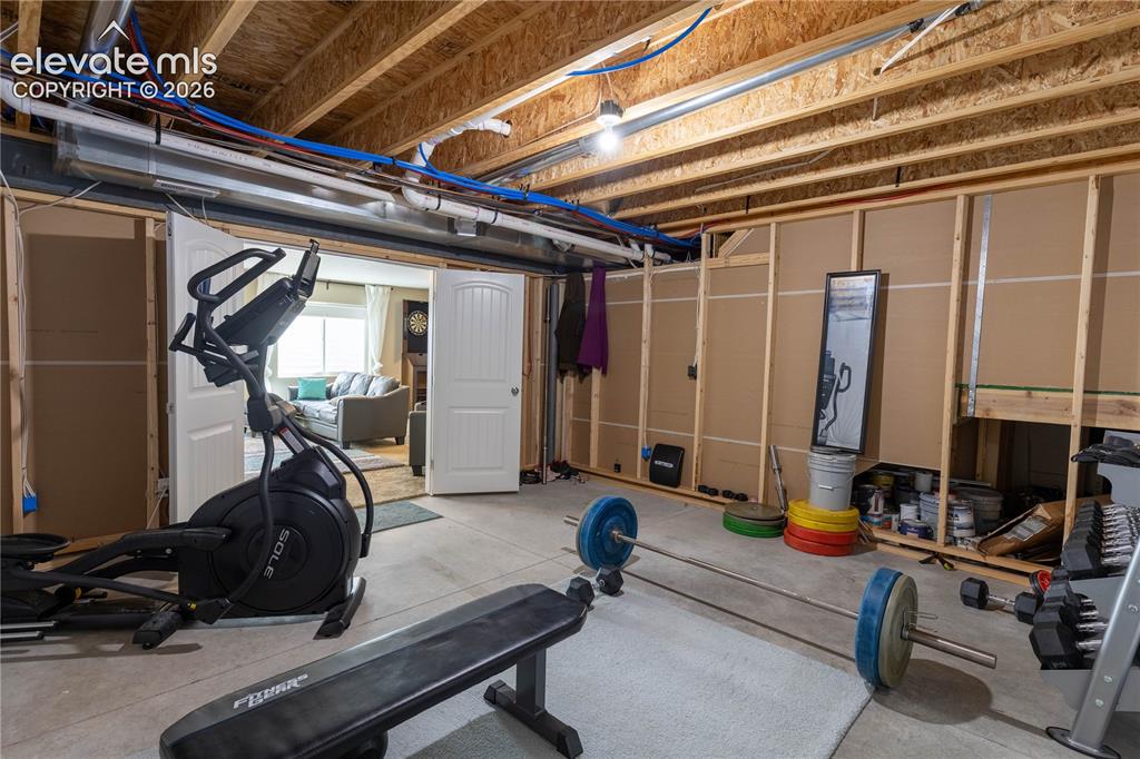 Image 28 of 37: Partially finished basement area with exposed joists and framing, featuring