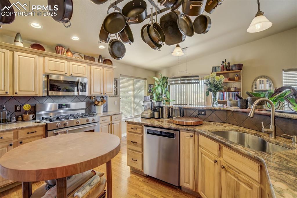 Image 11 of 50: Kitchen view showing the lightwood cabinetry, five burner gas range/oven, c