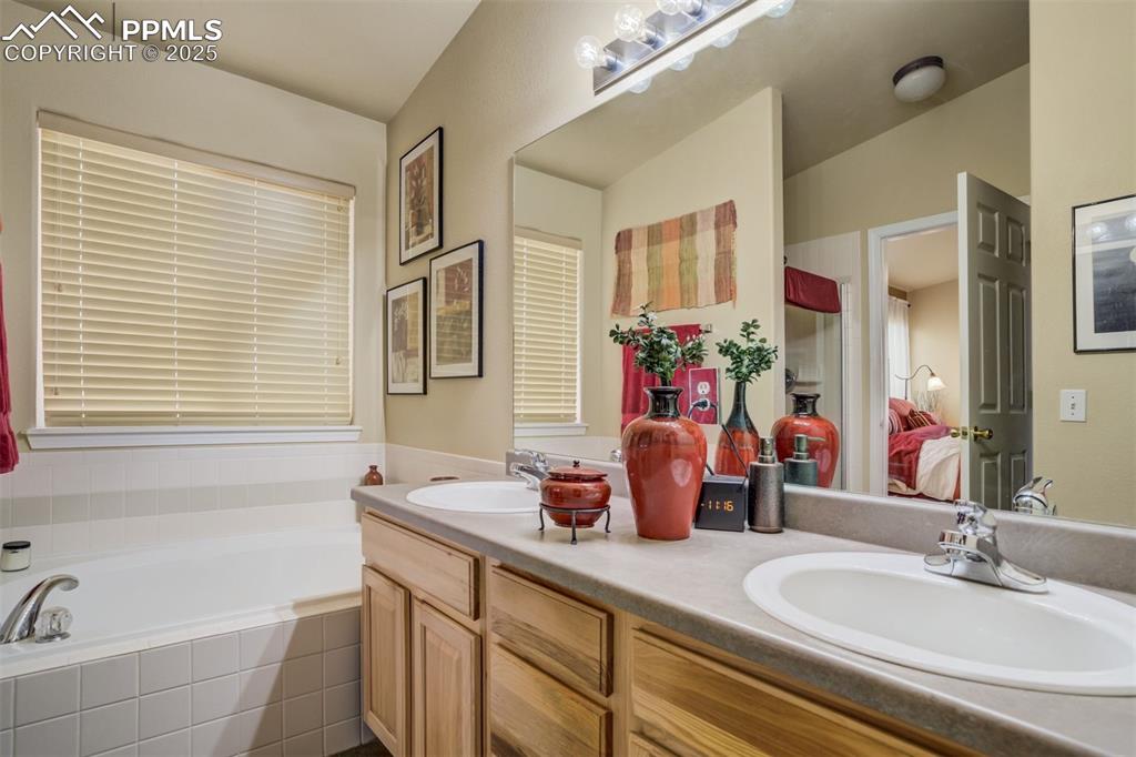 Image 18 of 50: Primary bedroom ensuite full bathroom with large soaking bath tub, double v