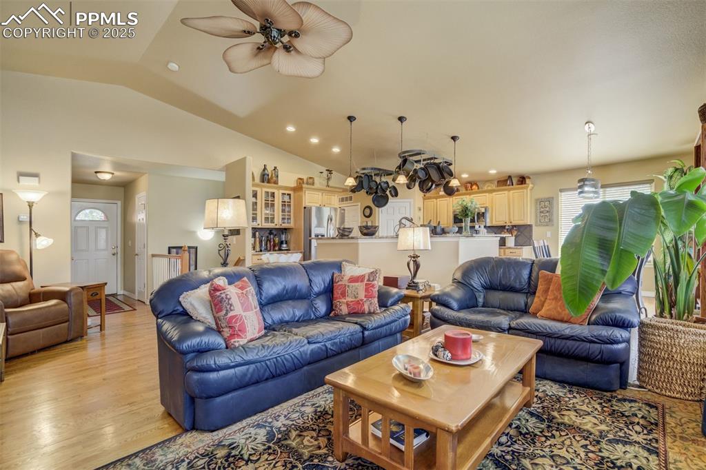 Image 8 of 50: Living area with lofted ceiling, light wood-style floors, recessed lighting