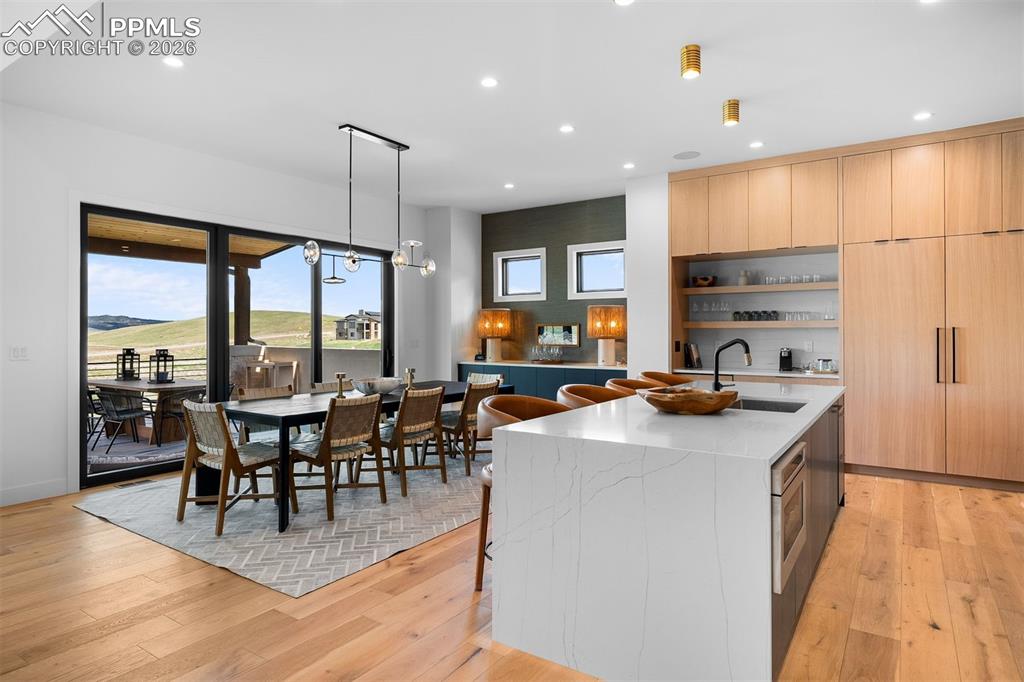 Image 15 of 37: Kitchen and dining positioned for effortless connection to the covered deck