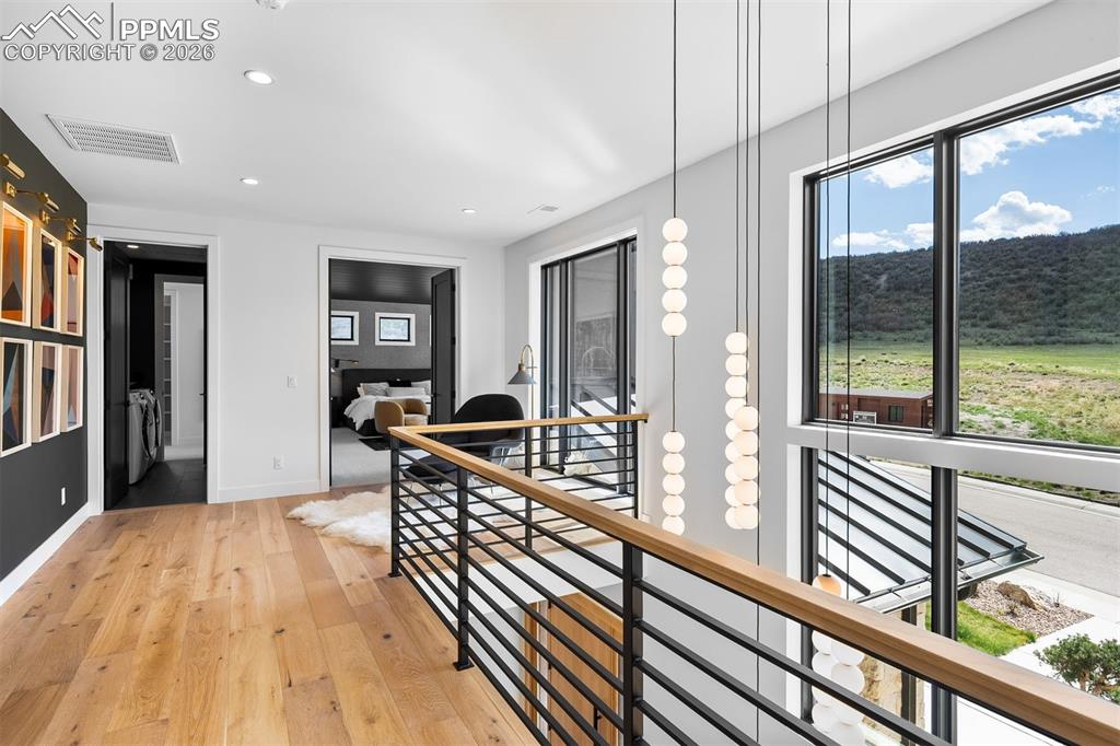 Image 17 of 37: Upper-level landing surrounded by expansive windows and modern railing deta