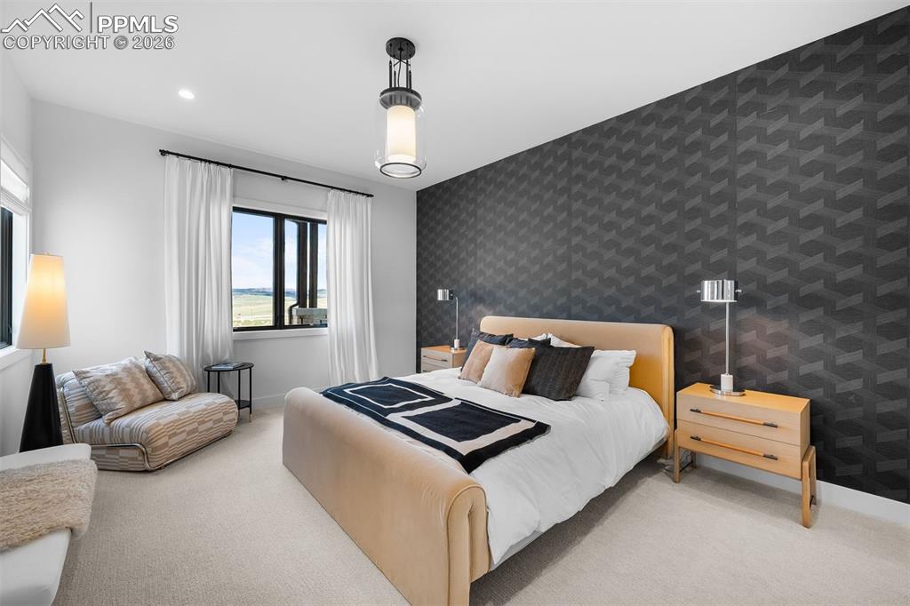 Image 24 of 37: Bedroom featuring statement accent wall and layered modern finishes.