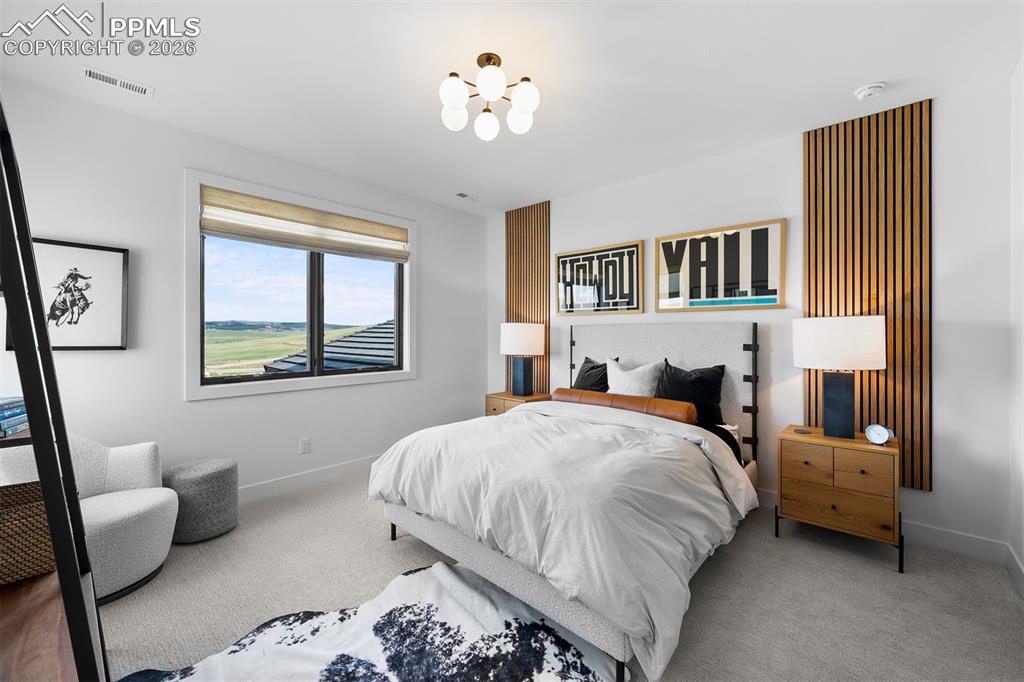 Image 27 of 37: Bedroom with custom vertical wood accents and framed views.