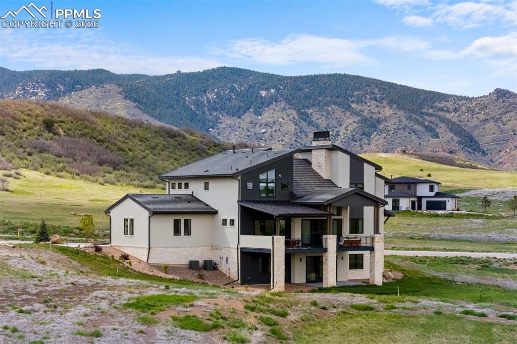 Image 35 of 37: Front elevation illuminated at dusk with mountain backdrop.