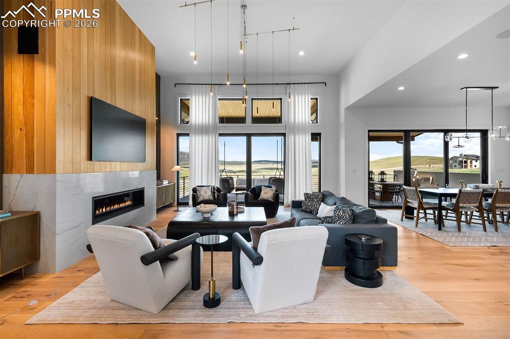 Image 5 of 37: Great room defined by soaring ceilings, walls of glass, and direct deck acc