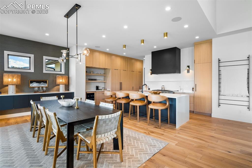 Image 6 of 37: Open-concept dining anchored by custom cabinetry and a quartz waterfall isl