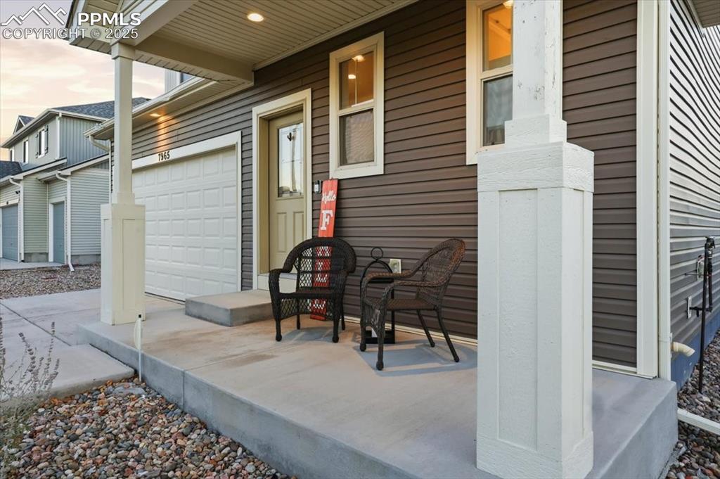 Image 3 of 41: Doorway to property featuring covered porch and a garage