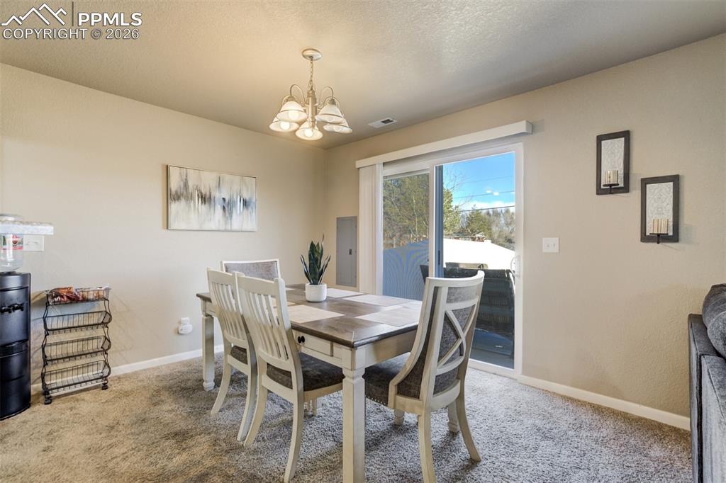 Image 12 of 50: Light-filled dining area featuring a stylish fixture and direct access to t