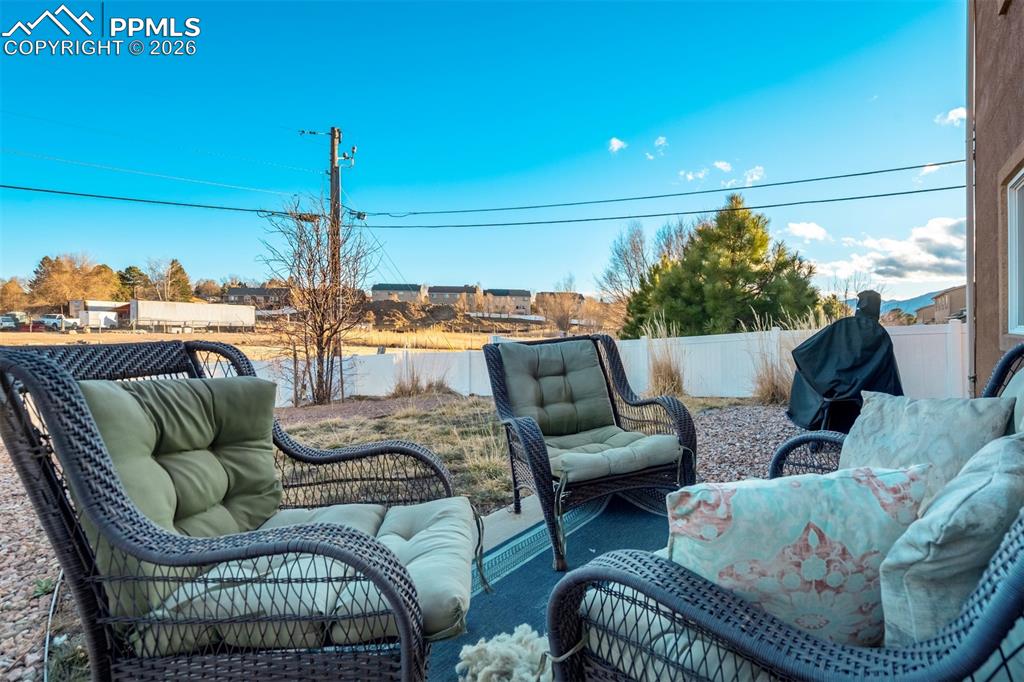 Image 43 of 50: Low-maintenance backyard with patio area, fenced perimeter, and open space—