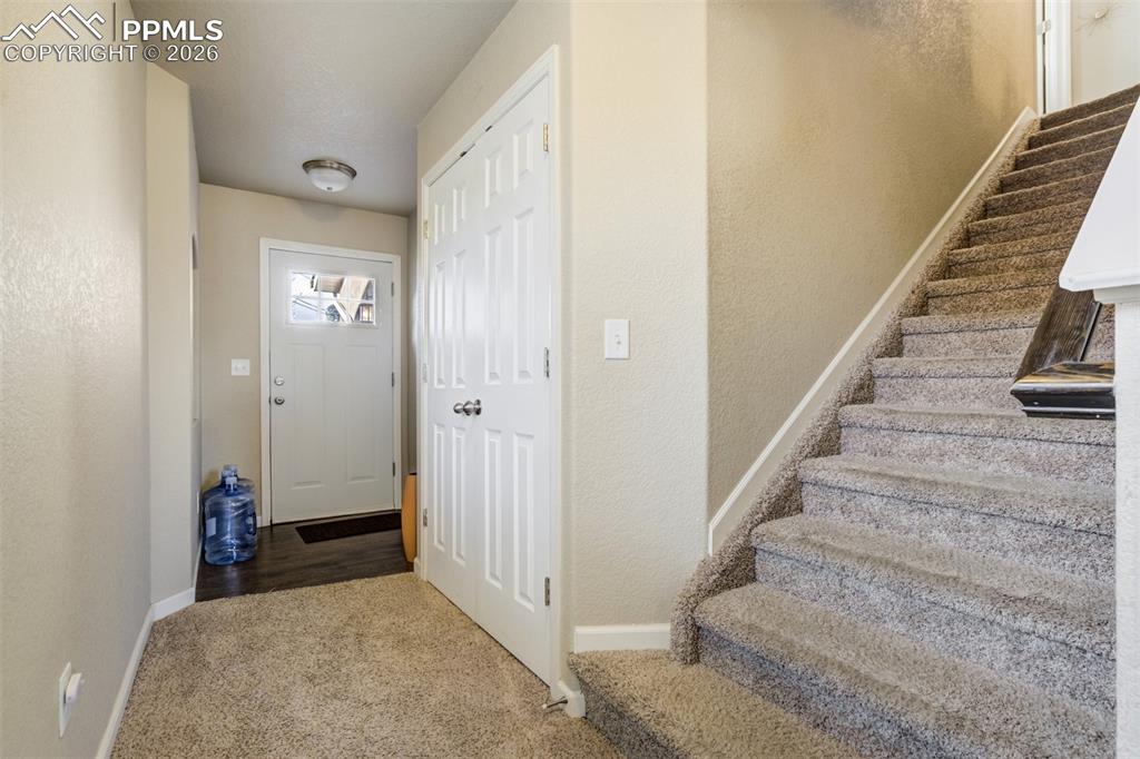 Image 5 of 50: Welcoming entryway with convenient coat closet, durable flooring transition