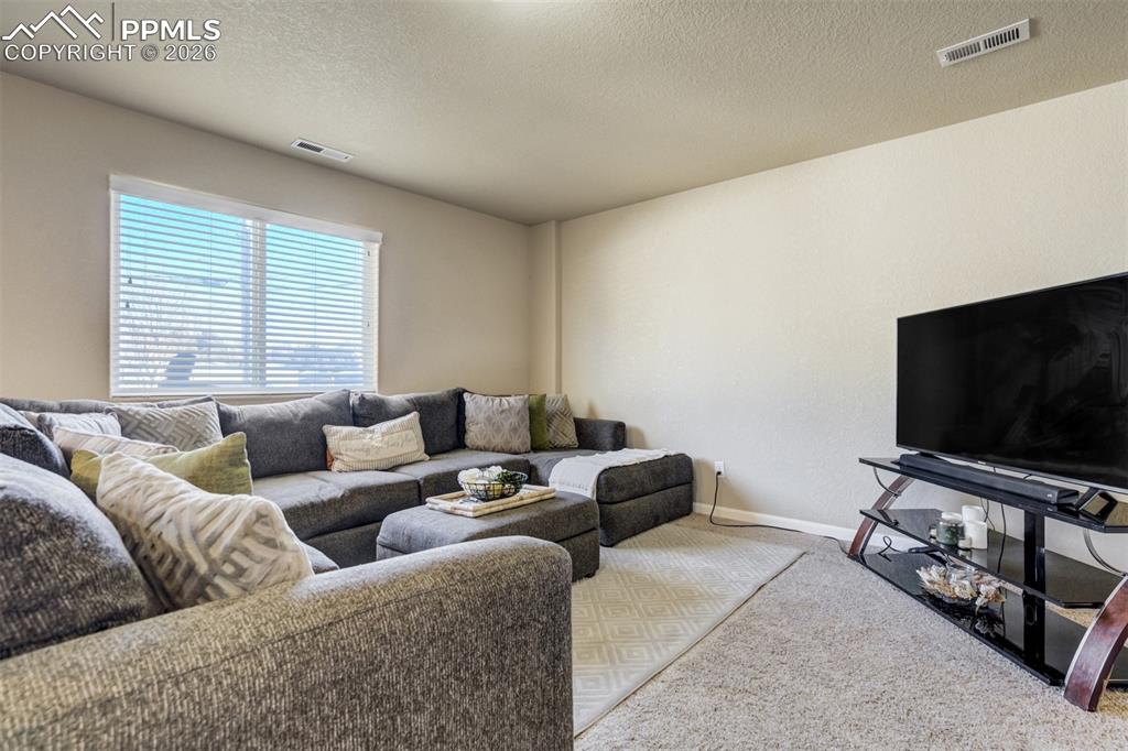 Image 6 of 50: Comfortable living room featuring plush carpeting, large sectional seating,