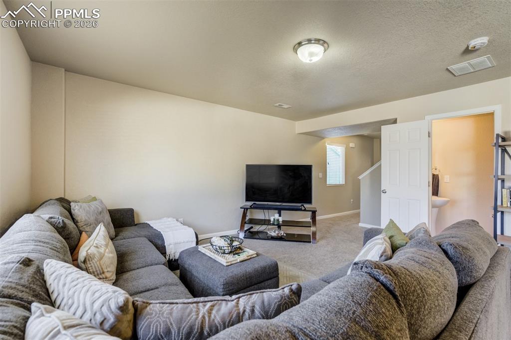 Image 9 of 50: Spacious living room with large window for natural light, cozy seating arra